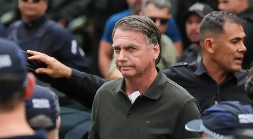 Bolsonaro está com expressão séria em meio a policiais.