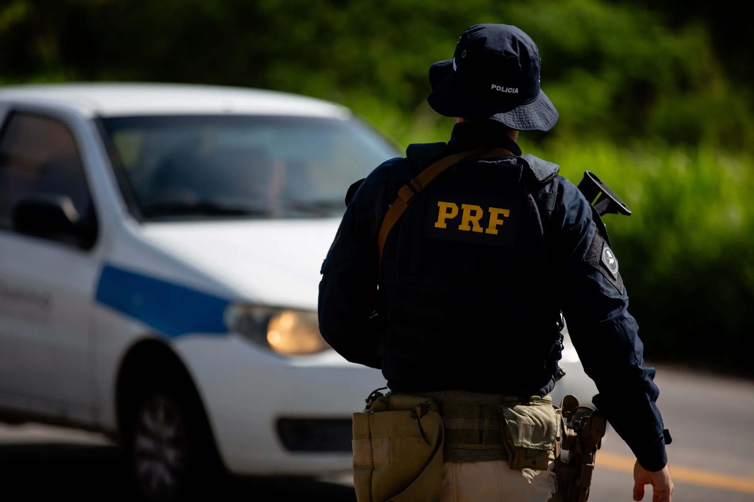 Agente da PRF faz o controle do fluxo em uma rodovia.