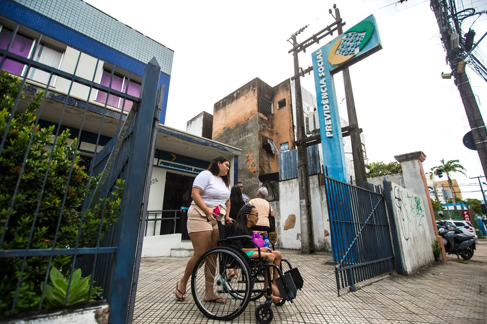 Pessoas chegando a agência da previdência social.