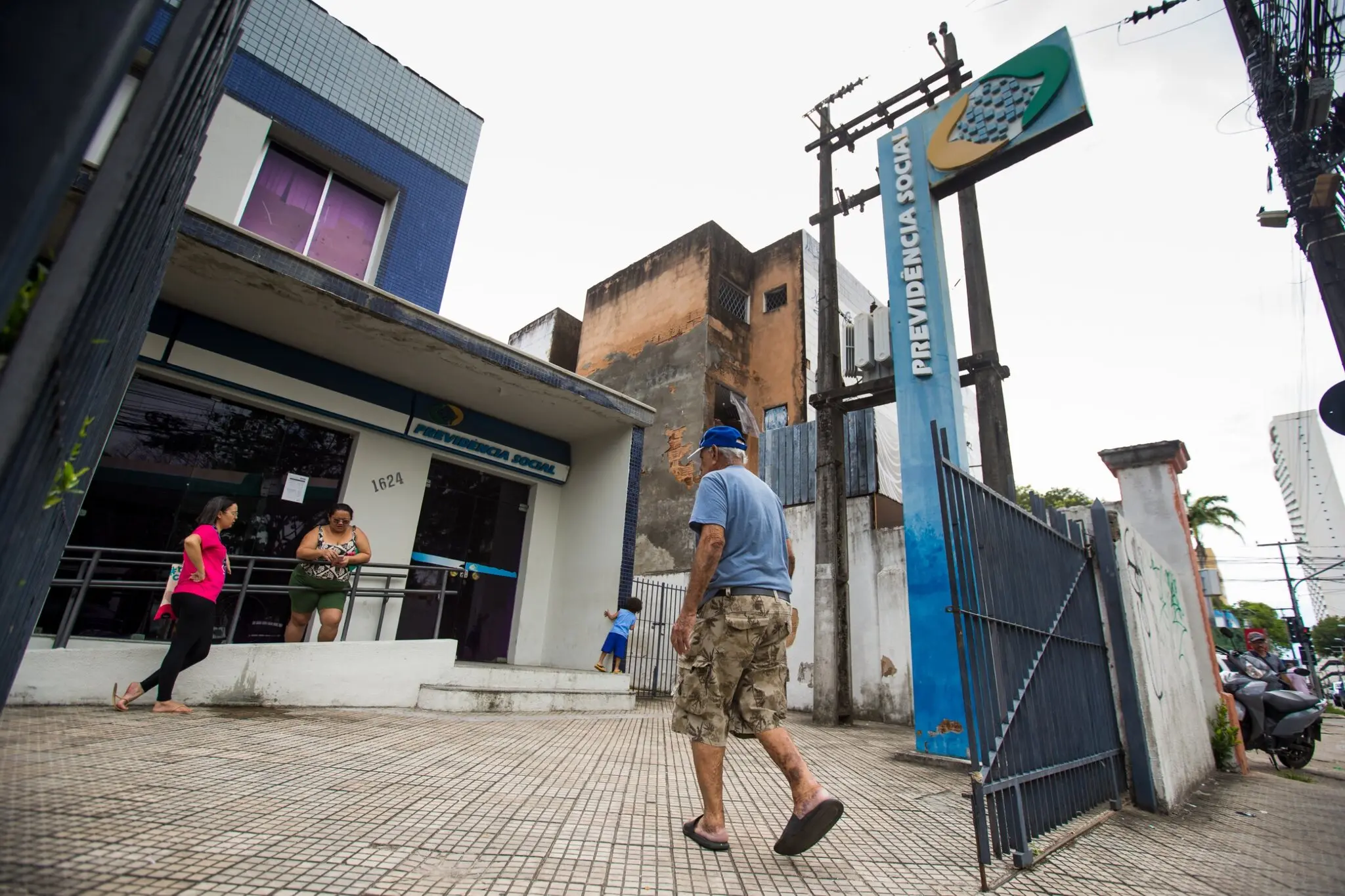 Pessoas chegando a agência da previdência social.