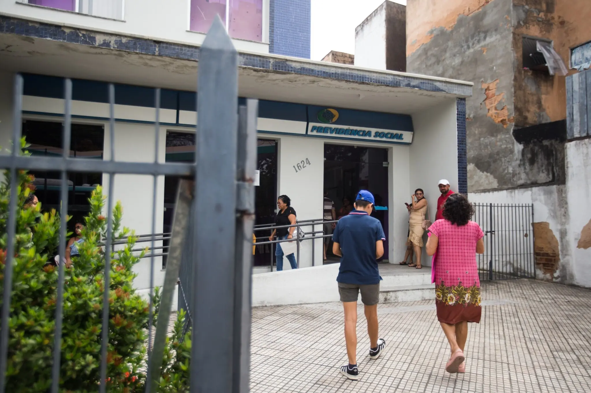 Pessoas chegando a agência da previdência social.