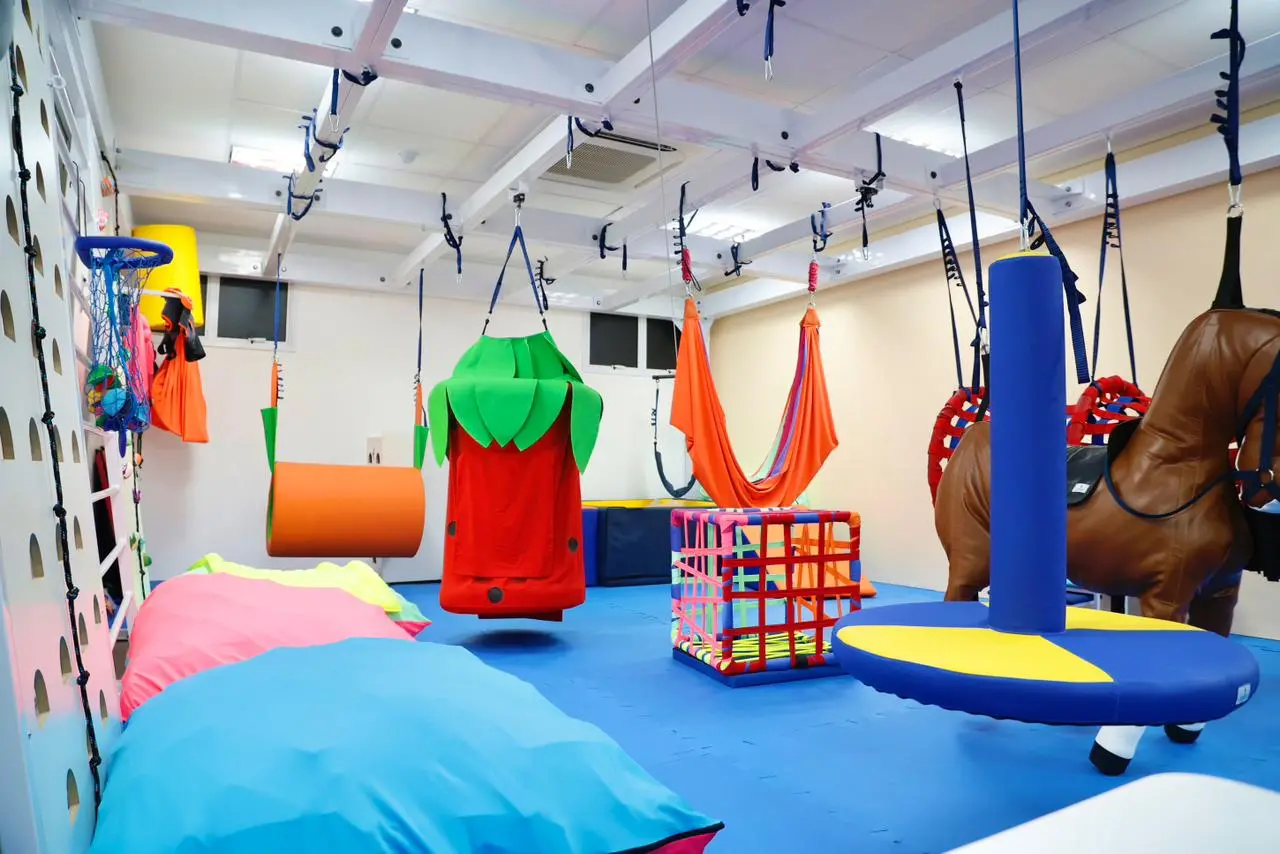 Sala de Espaço Girassol em Fortaleza com redes, almofadas e brinquedos coloridos para regular as emoções de pessoas com TEA.