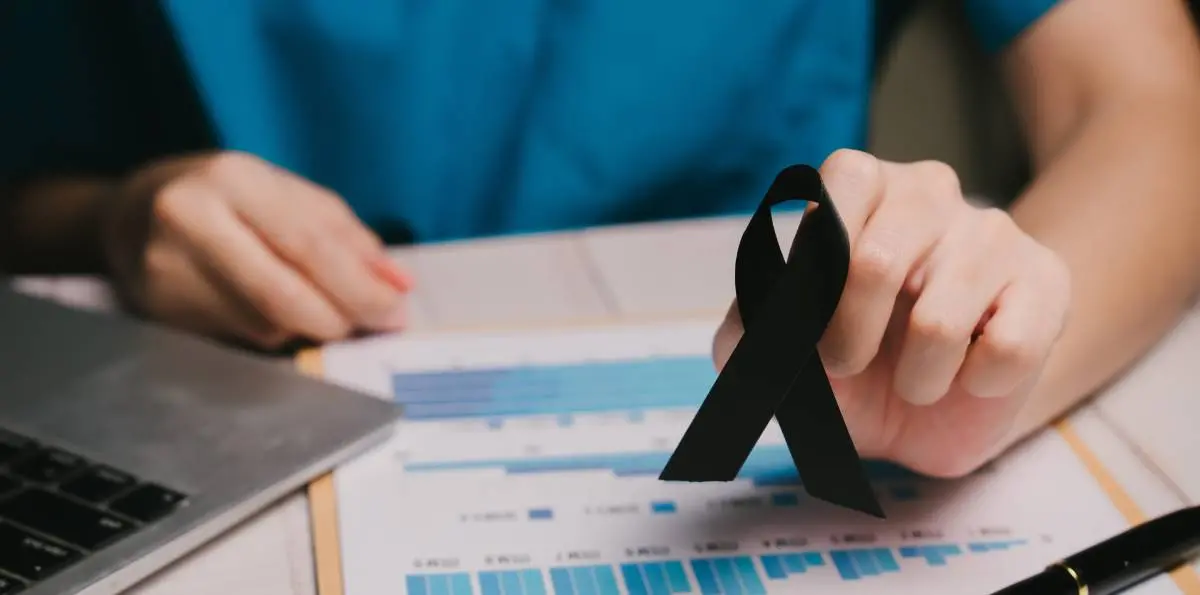 Imagem ilustrativa com uma pessoa segurando uma fita de luto.