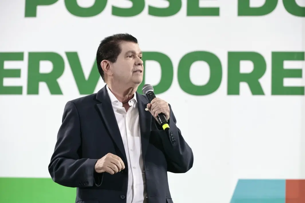 Mauro Filho discursa durante evento de posse de novos servidores do Governo do Ceará. Ele veste um blazer e segura um microfone.