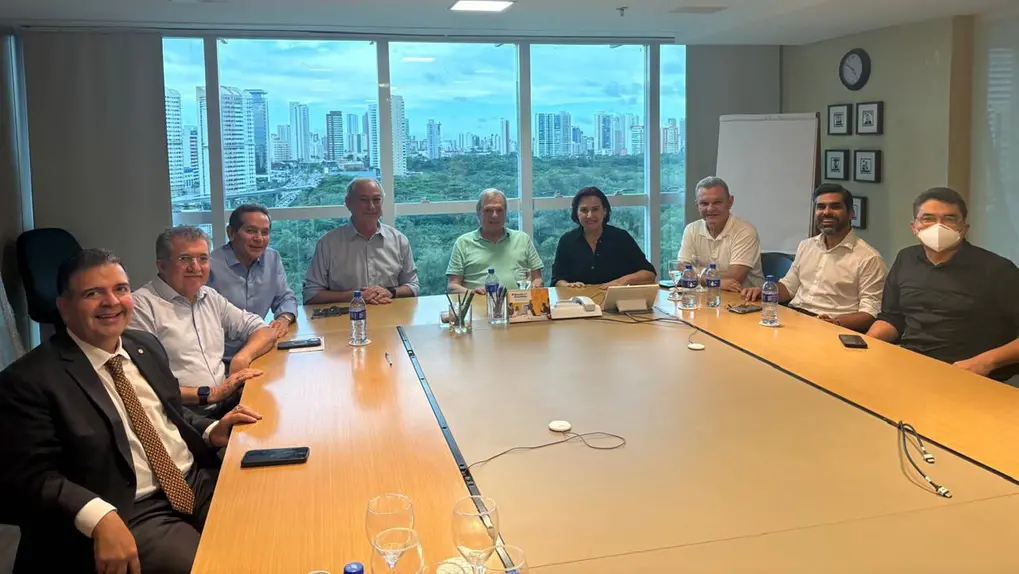 Ciro e Tasso ao lado de deputados estaduais do PSDB. Eles estão sentados ao redor de uma mesa.