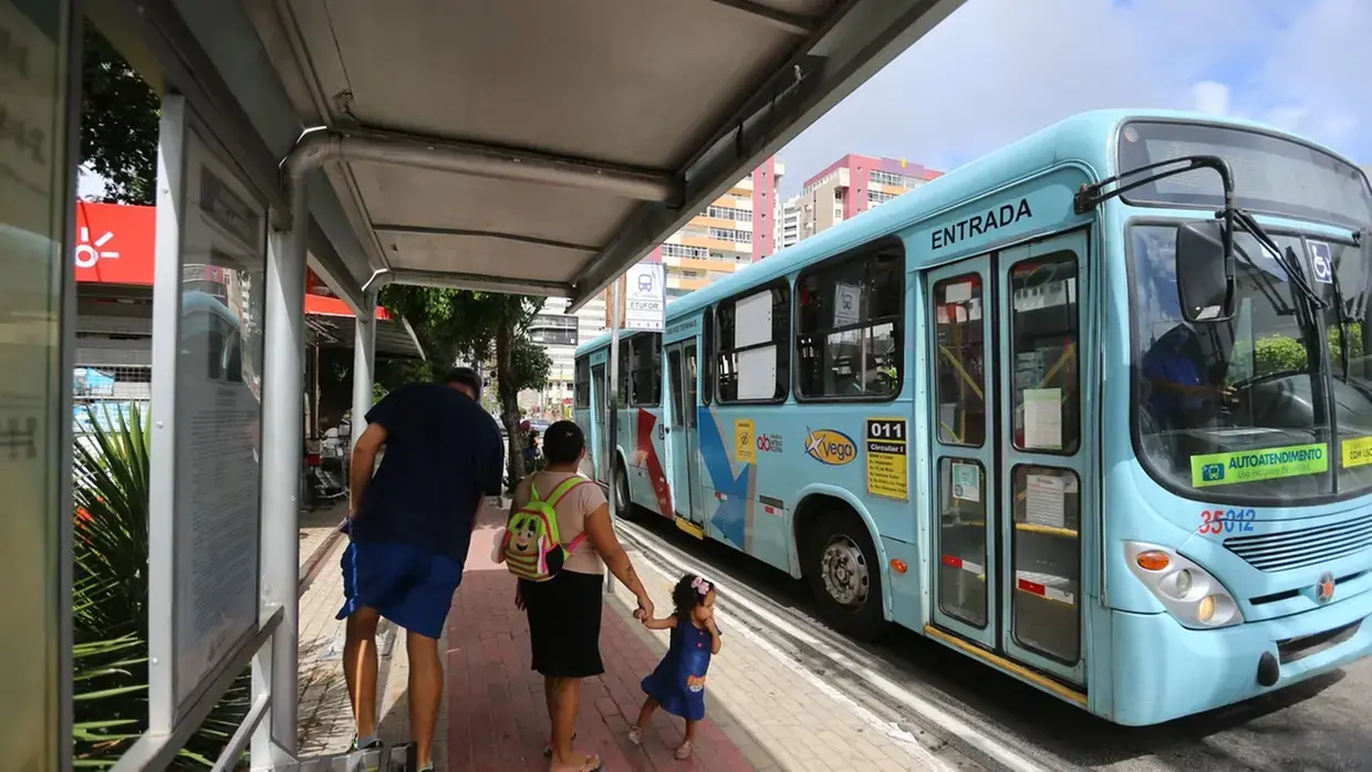 Homem, mulher e criança à espera de ônibus em Fortaleza.