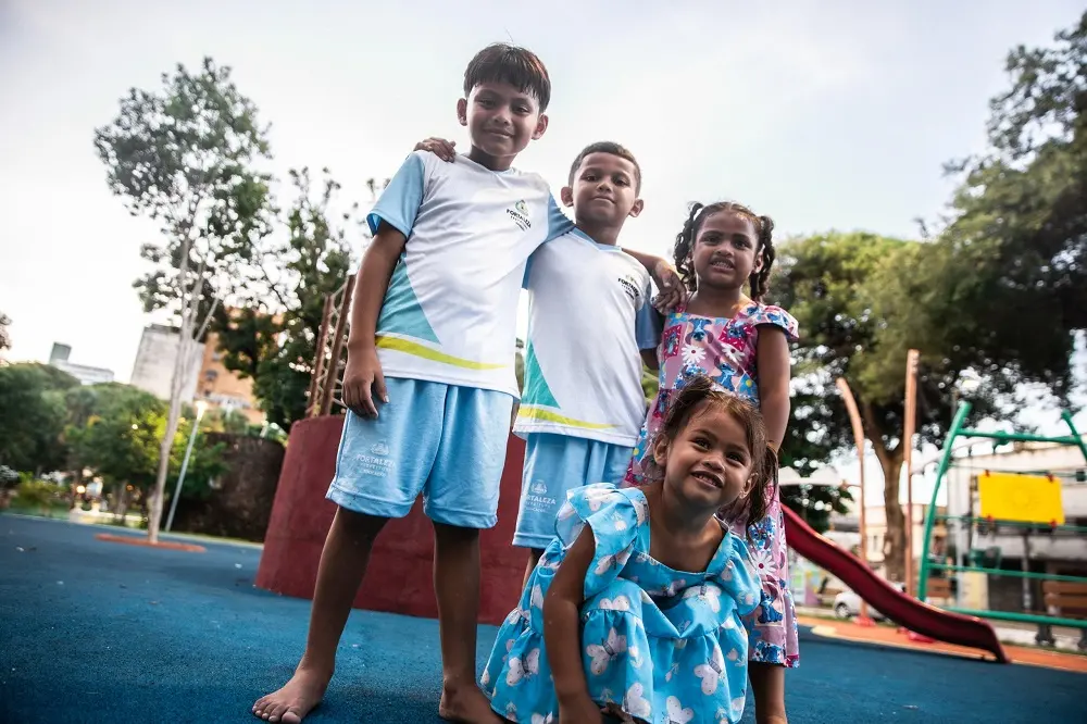 Irmãos se divertem no parquinho após a escola.