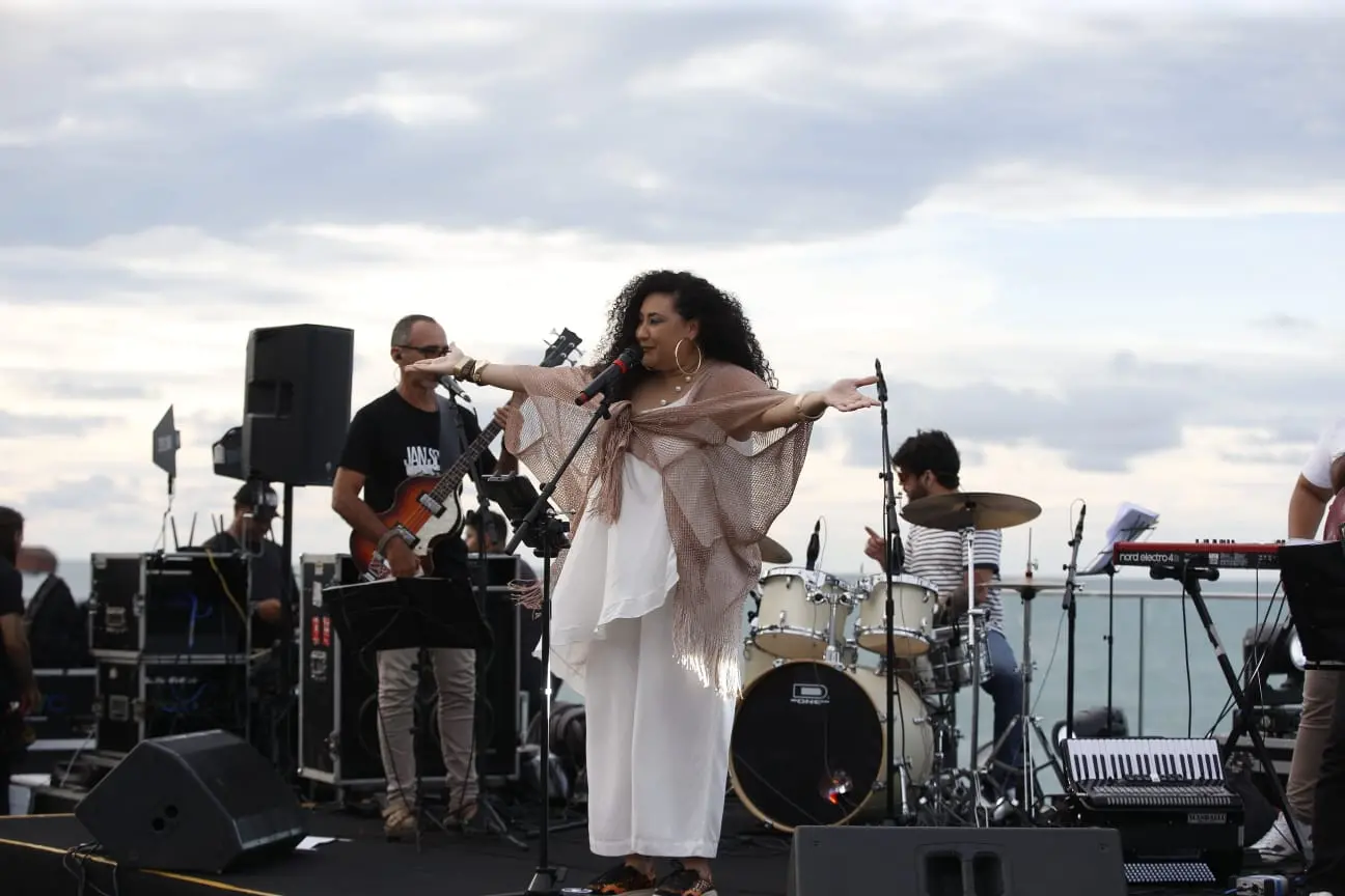 Mulher fazendo apresentação musical ao ao livre durante aniversário de Fortaleza.