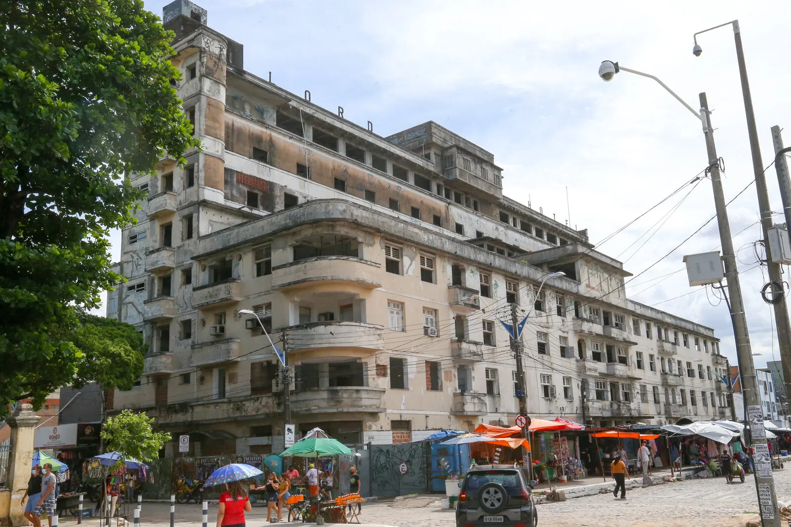Fachada do antigo Lord Hotel na Praça José de Alencar, exibindo sua arquitetura monumental em estilo art déco, atualmente em processo de degradação e cercado por comércio popular.