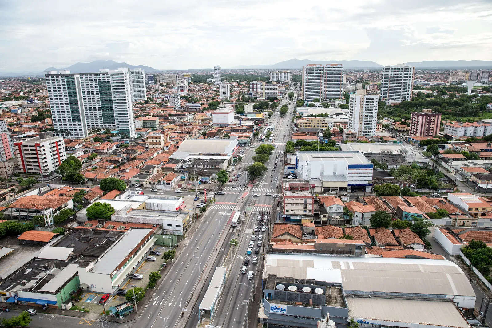 Registro atualizado da Avenida Bezerra de Menezes destacando grandes torres residenciais modernas em primeiro plano e a densidade urbana que se estende até as montanhas da Região Metropolitana.