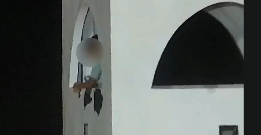 Jovem raspa pintura de parede em mirante na Praia de Iracema.