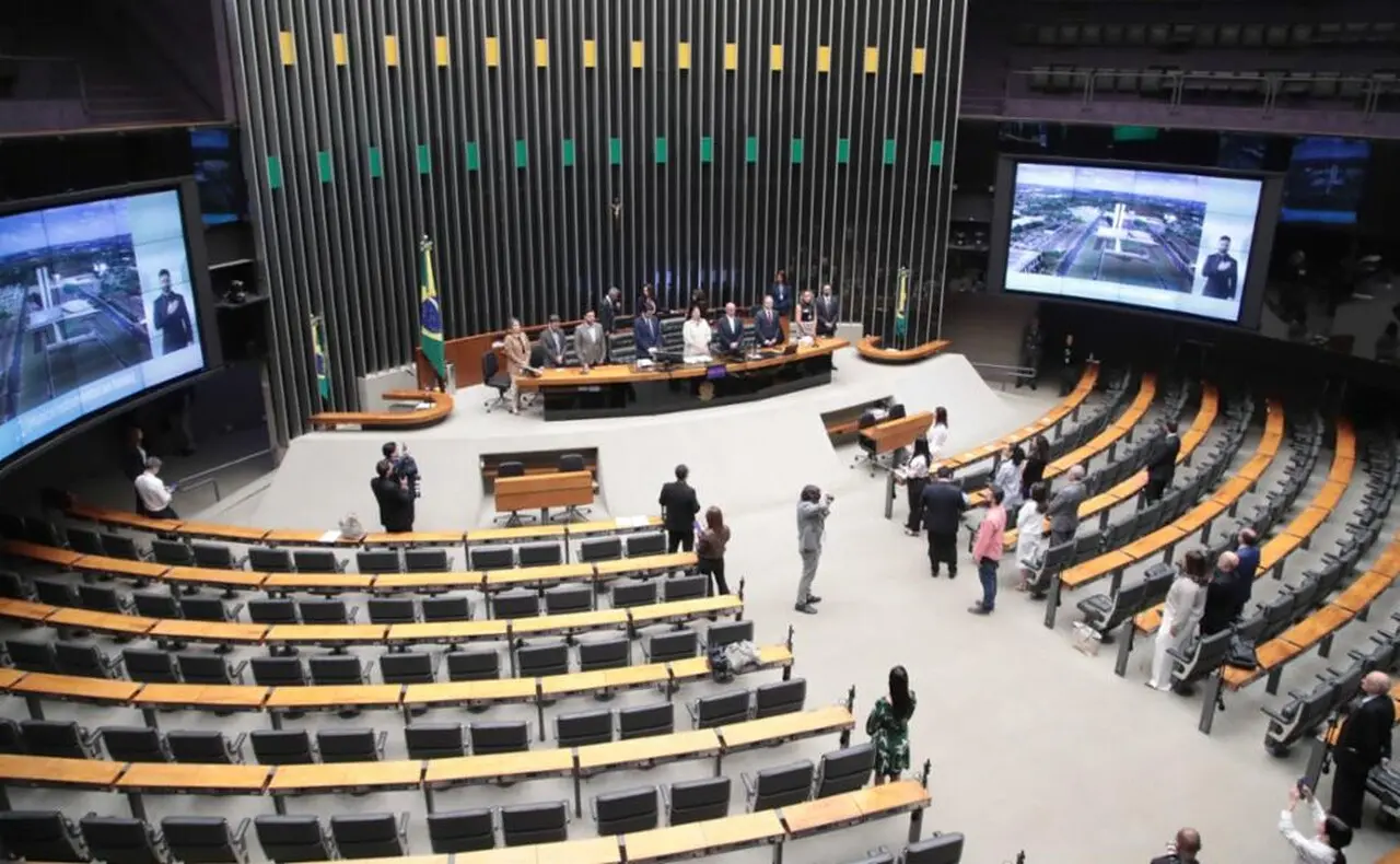 Imagem aérea interna do Plenário da Câmara, com maioria das cadeiras vazias e algumas pessoas em pé espalhadas pelo local.