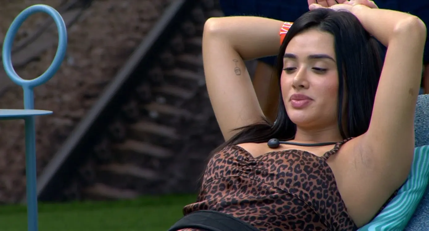 Jordana deitada em cadeira com os braços apoiados atrás da cabeça.