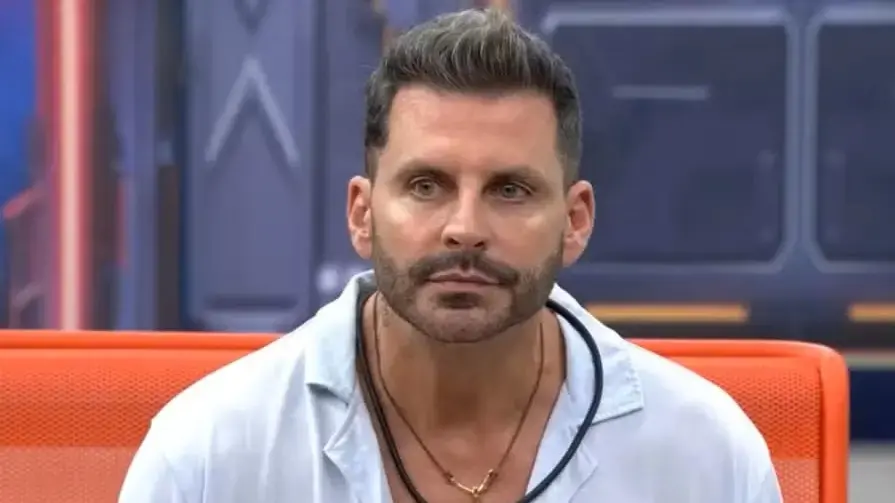 Henri Castelli é um homem branco de meia idade, loiro, de cabelo penteado para cima. Na foto, ele está com expressão séria e usa camisa branca de gola polo.