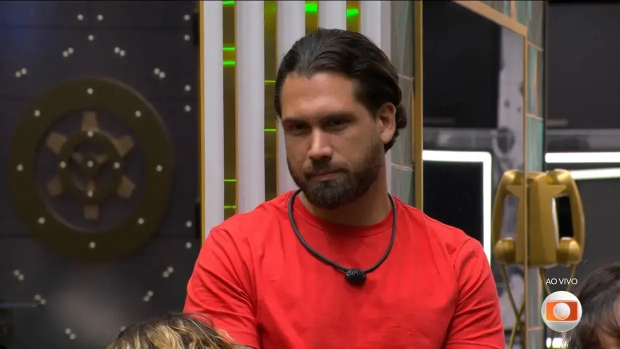 Brigido é um homem de meia idade, branco, de cabelo penteado para trás. Na foto, ele usa camisa vermelha.