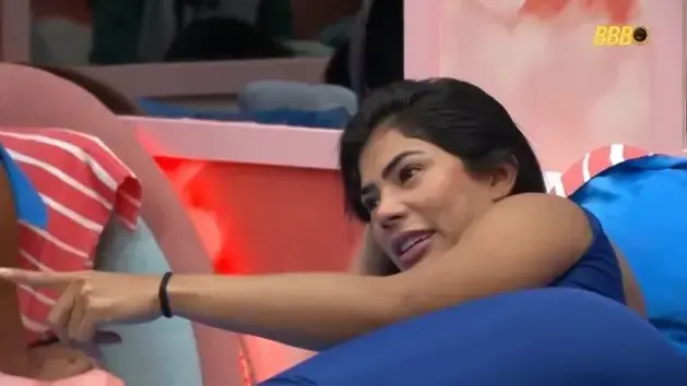 Marciele é uma mulher indígena de cabelo preto liso. Na foto, ela está deitada conversando com alguém.