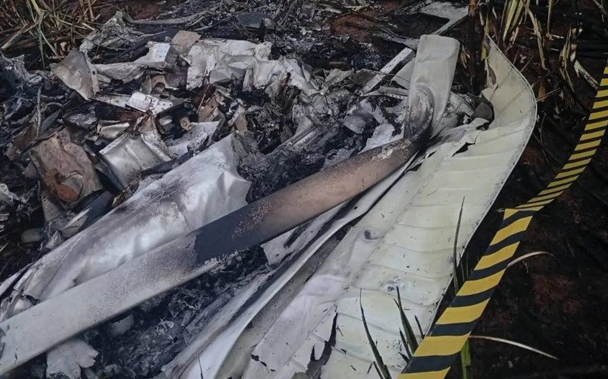 Destroços de avião em cima de grama, em um descampado. Na imagem, eles estão cercados por fita de isolamento.
