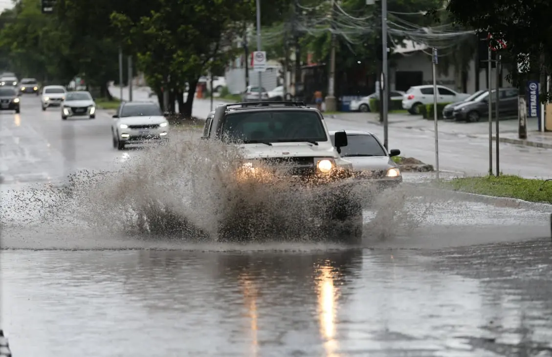 Carro passa em poça d'água durante chuva em Fortaleza.