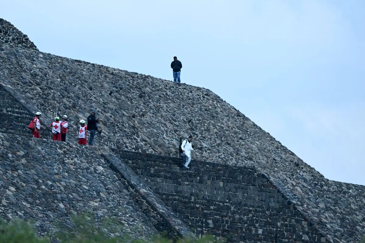 Pessoas descem a escadaria lateral de uma grande pirâmide de pedra no México, enquanto outras permanecem posicionadas no topo e em diferentes níveis da estrutura. Foto aconteceu após ataque a tiros que deixou brasileiros feridos.