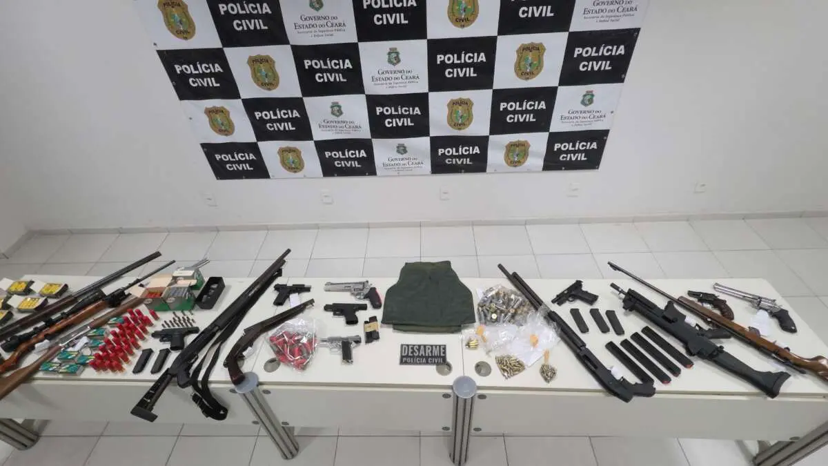 material apreendido exposto em mesa armas municoes colete.