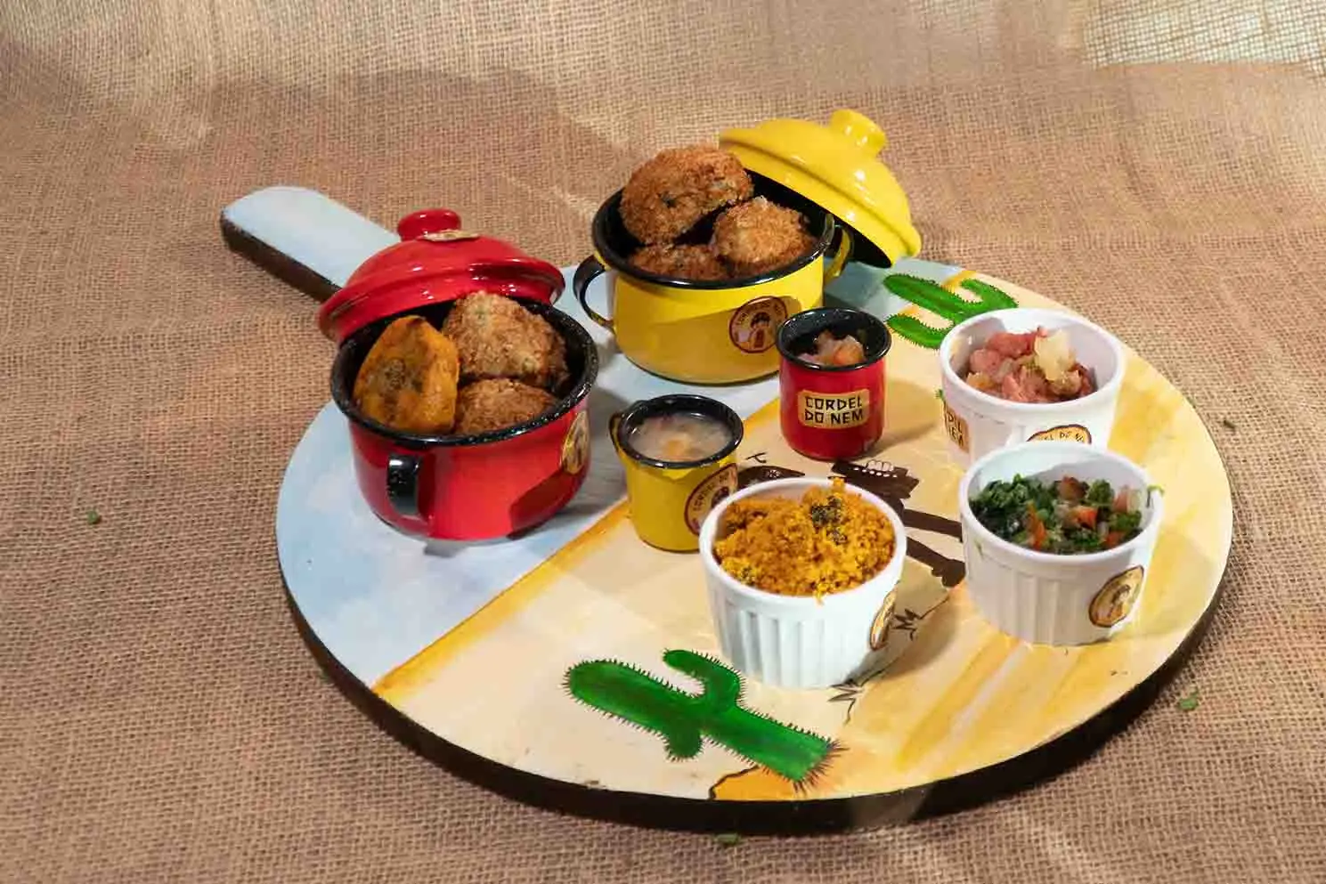 Bolinhos de feijão-verde e acompanhamentos de farofa e molhos.