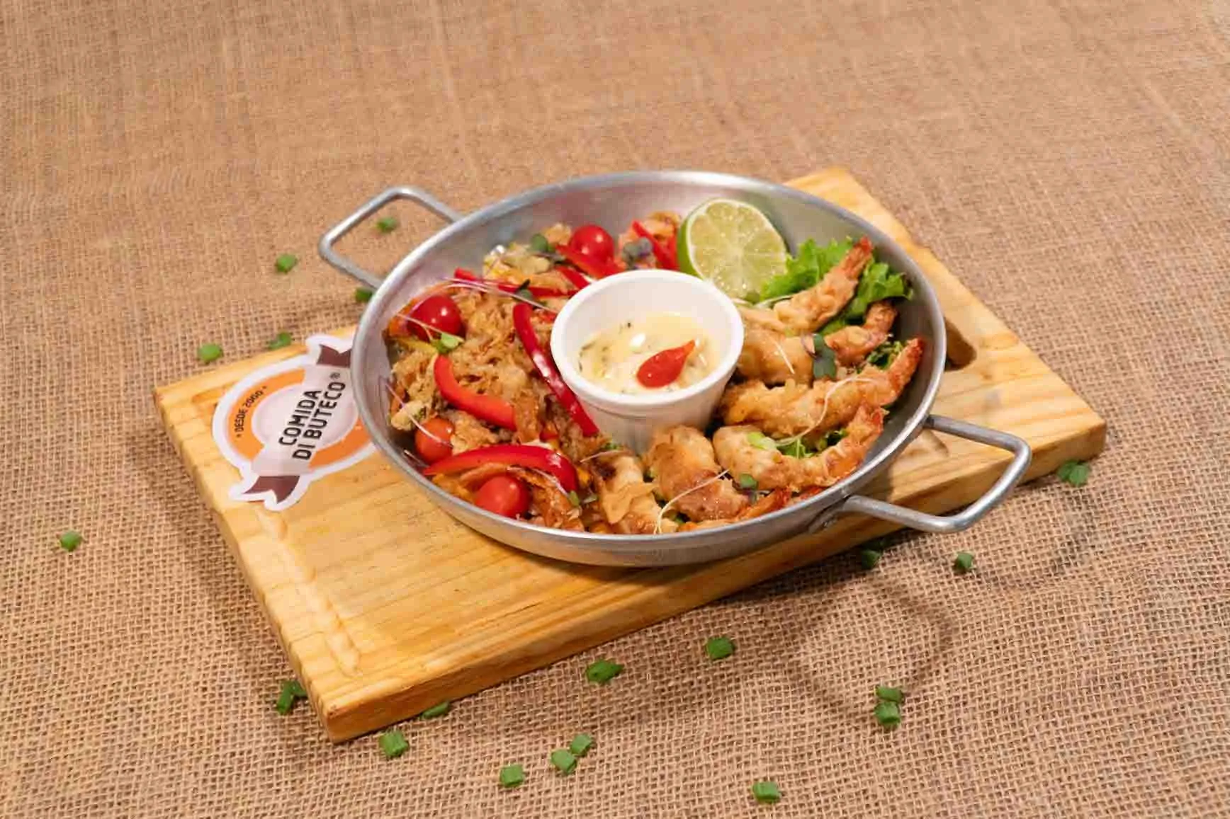 É servido um tempurá de camarão com mix de legumes, servido com molho agridoce.