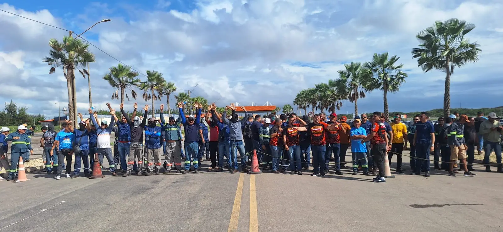Homens manifestantes protestam com mãos para cima.
