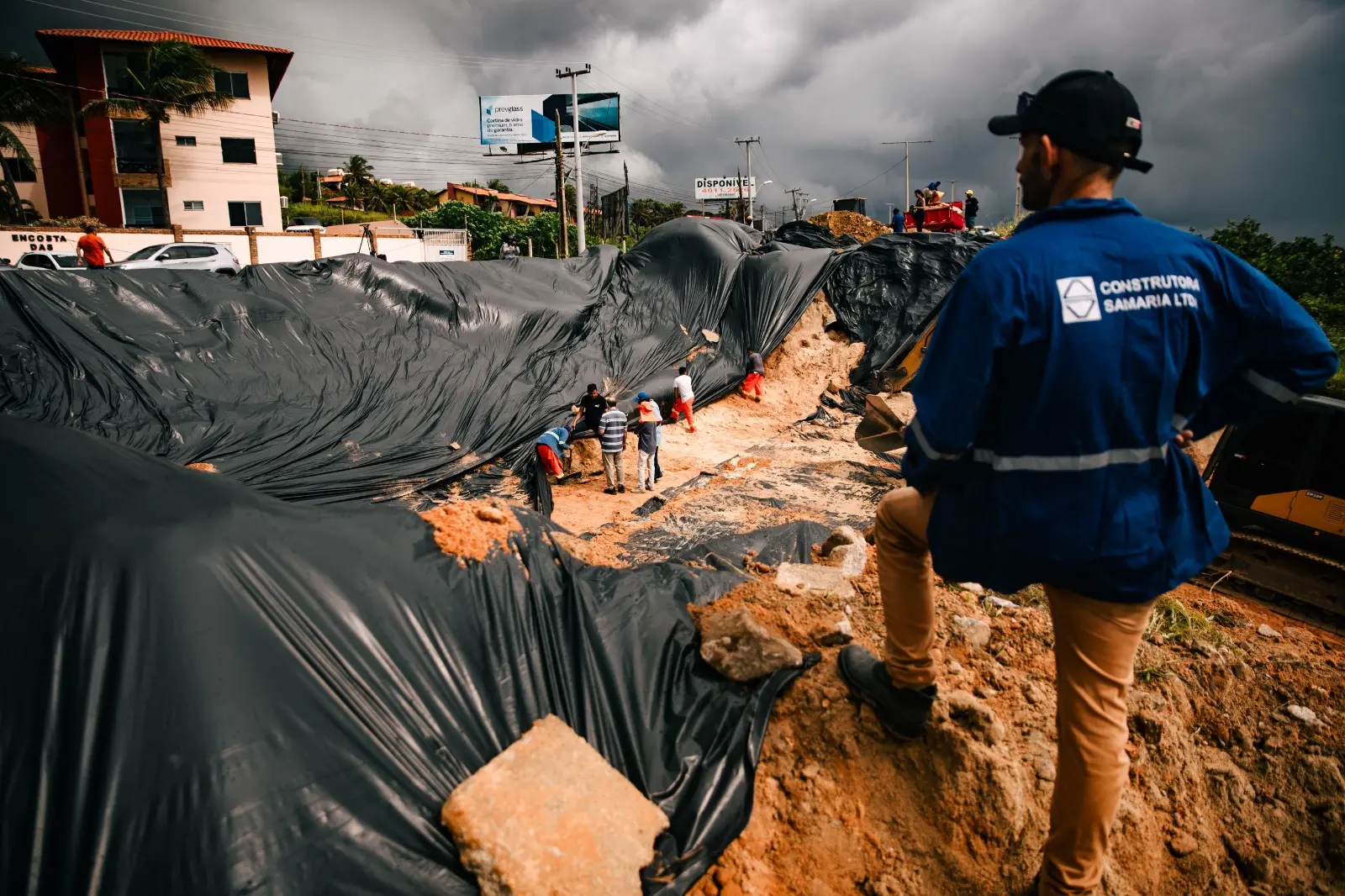 Imagem mostra trabalhador observando recuperação de cratera que se abriu em aquiraz na ce-025.