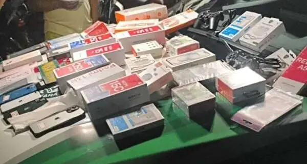 Produtos eletrônicos roubados dispostos sobre capô de viatura da Polícia Militar.