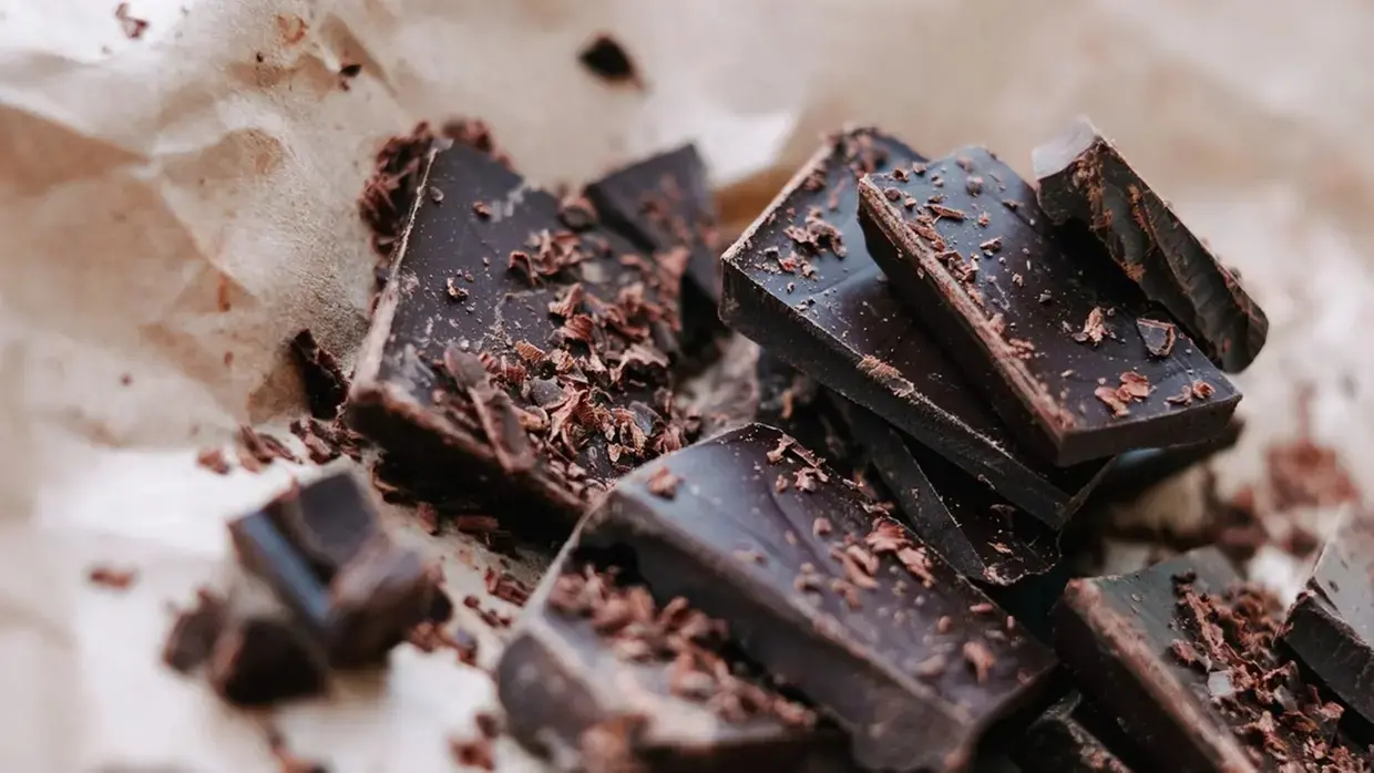 pedaços escuros de chocolate, cortados em uma superfície branca.