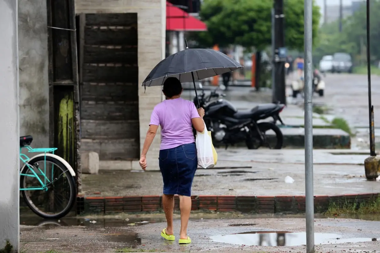 mulher andando na rua em dia chuvoso com guarda-chuva