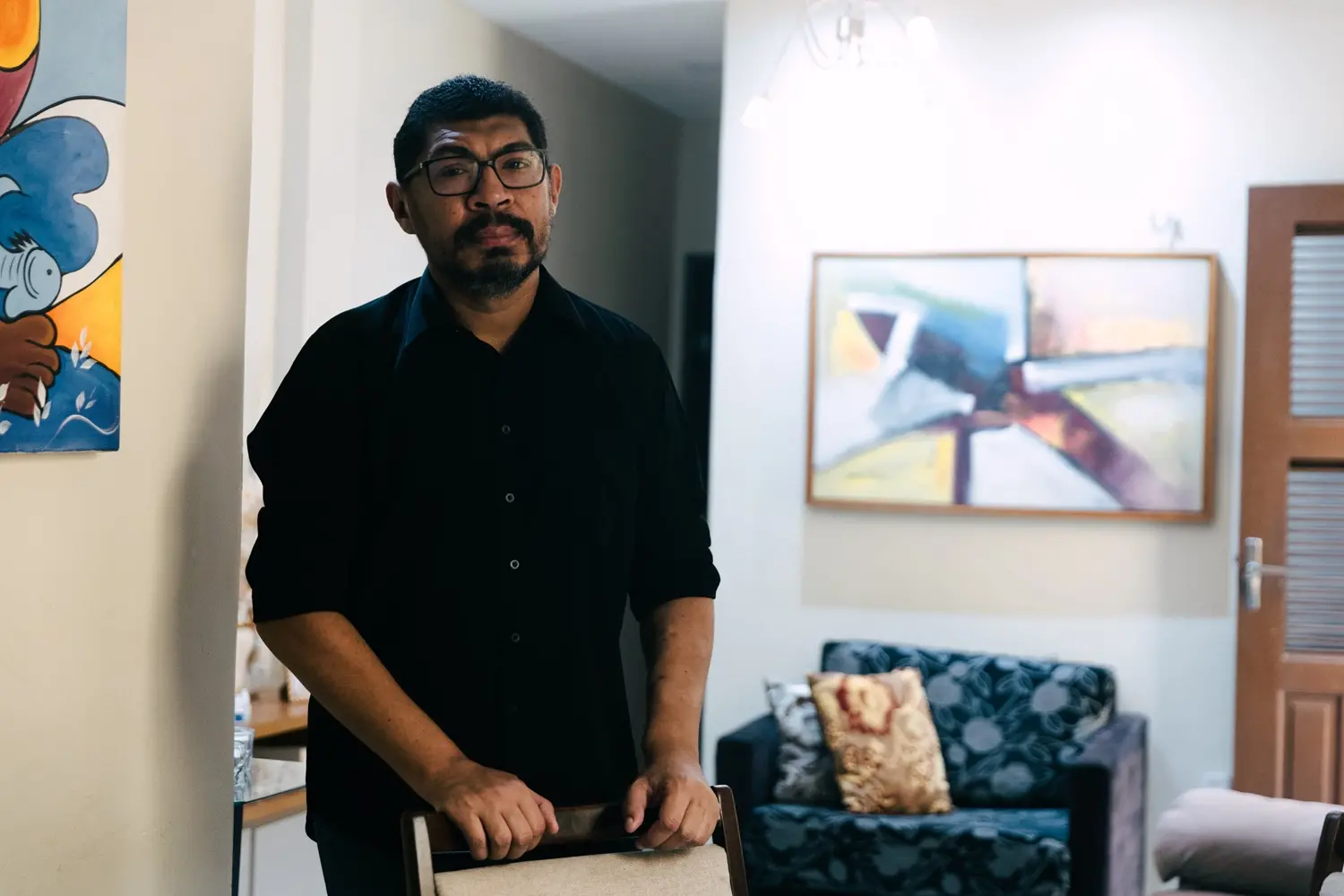 Tiago na sala da casa onde mora, em Fortaleza.