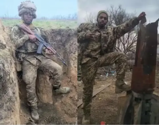 Homem negro em vestes militares e segurando espingarda.