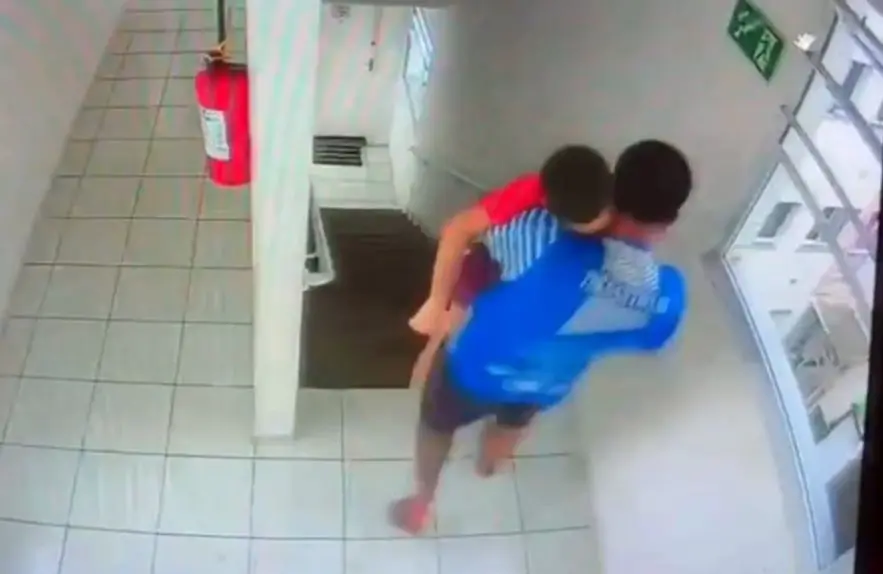 padrasto e enteado nos braços, corredor predio, apartamento.