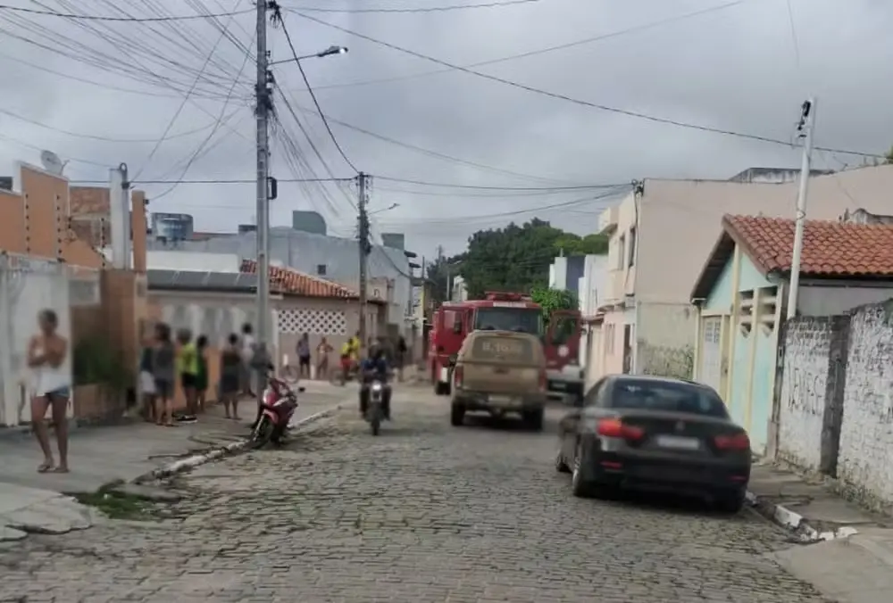 Imagem de uma rua com movimentação policial e de populares.