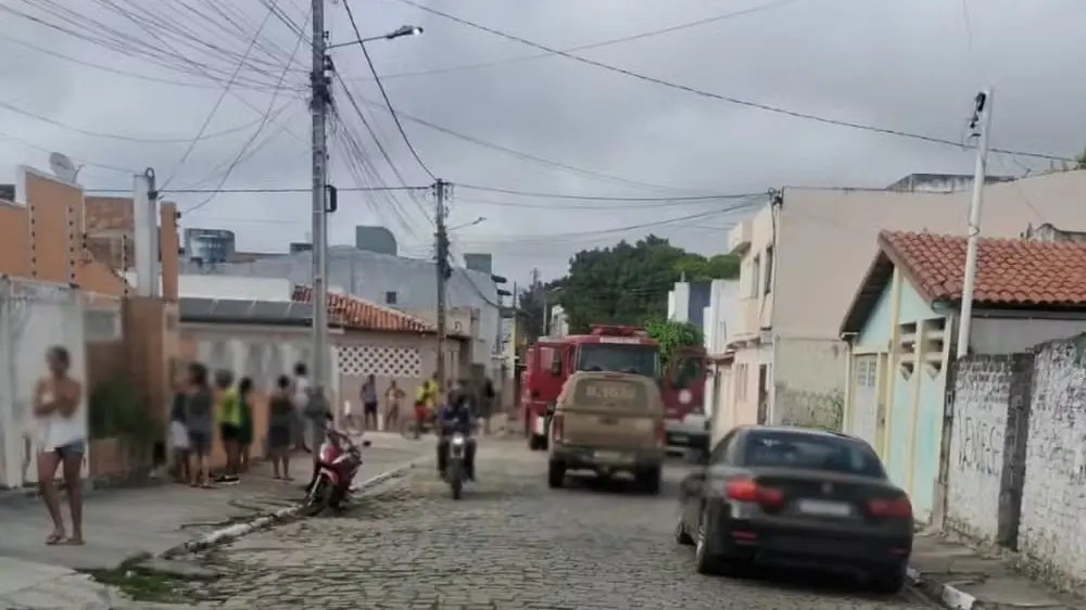 Imagem de uma rua com movimentação policial e de populares.