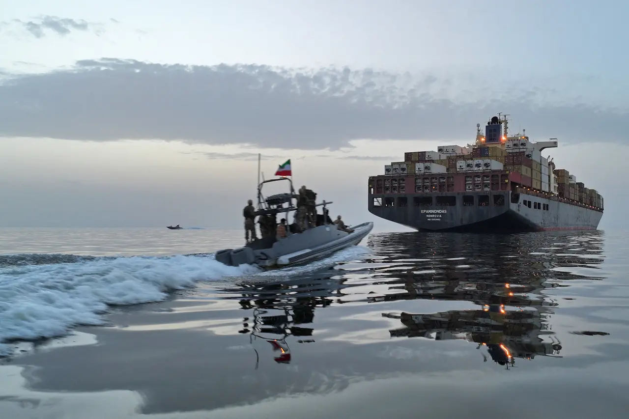 Um barco militar de patrulha do Irã com soldados armados navega em águas calmas em direção a um grande navio cargueiro carregado de contêineres. A cena ocorre sob um céu de crepúsculo, com os reflexos das embarcações projetados na superfície da água em uma composição que transmite movimento e vigilância.