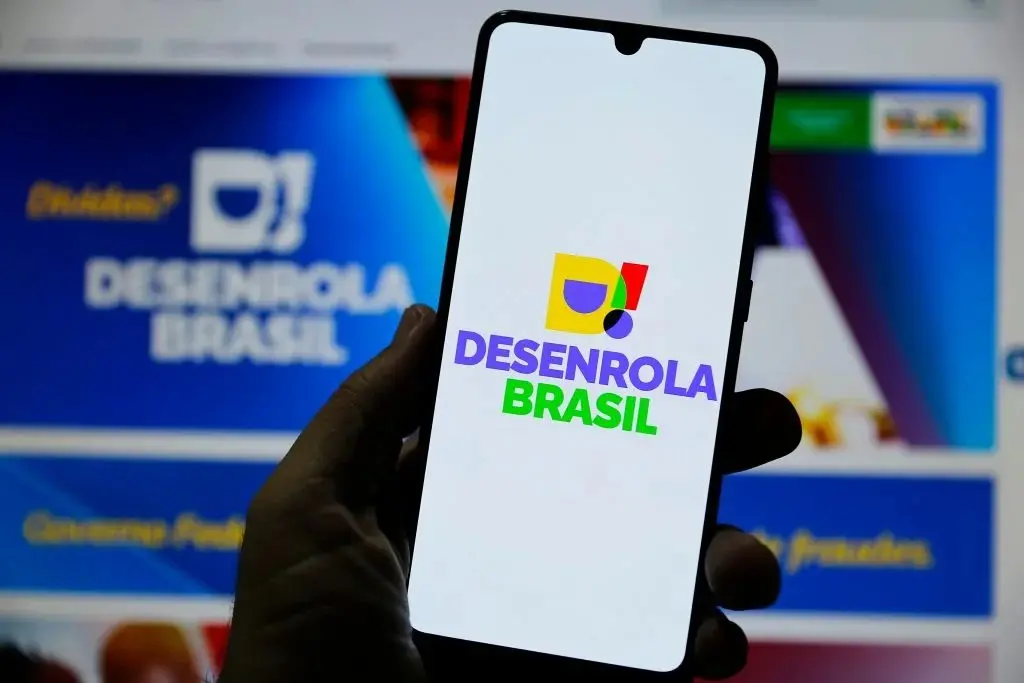 Imagem mostra mão de uma pessoa segurando o celular no app do desenrola.