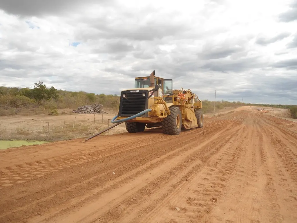Foto que contém pavimentação da CE-266. Trecho está todo em terra, com um trator na estrada.