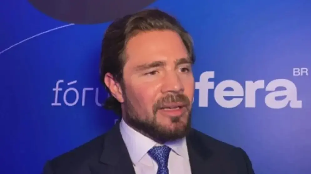 Vorcaro é um homem branco, de barba rala e cabelo liso penteado para trás. Na foto, ele está de terno preto, camisa social azul clara e gravata azul escura.