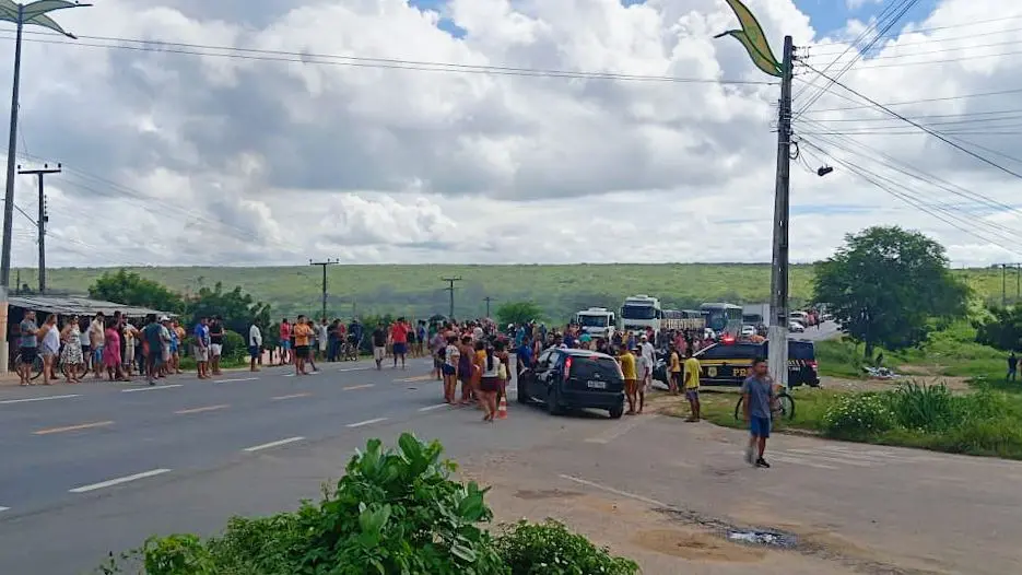 Protestantes ocupam trecho da rodovia BR-020, no interior do Ceará. Caminhões estão parados à espera de passagem.