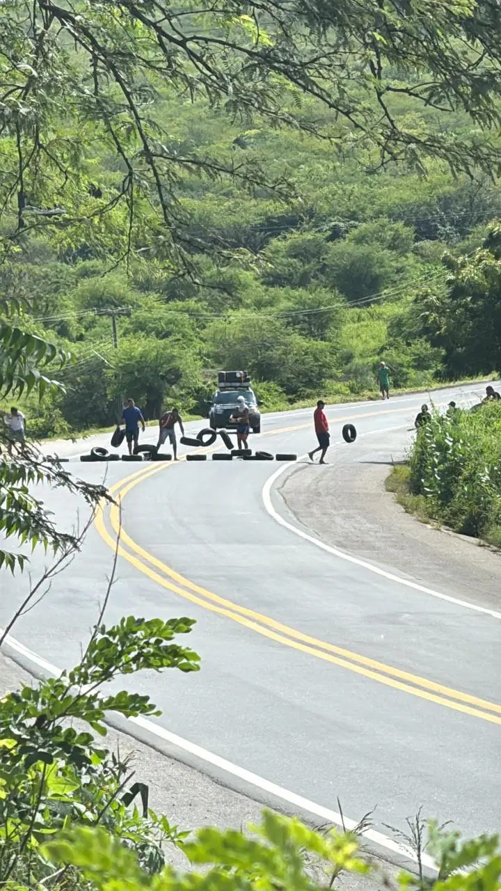 Manifestantes colocam pneus na rodovia para impedir o tráfego de veículos.