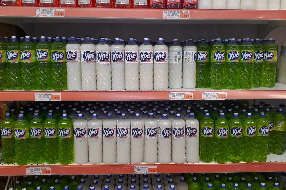 Detergentes da Ypê em prateleiras de supermercado.
