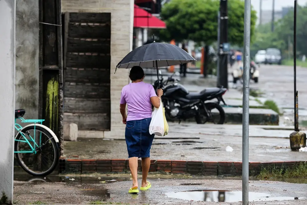 imagem de uma mulher andando com guarda-chuva na rua