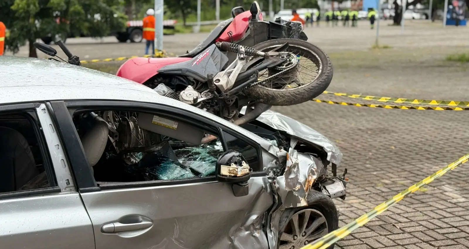 Cena fictícia de colisão de trânsito entre carro e motocicleta.