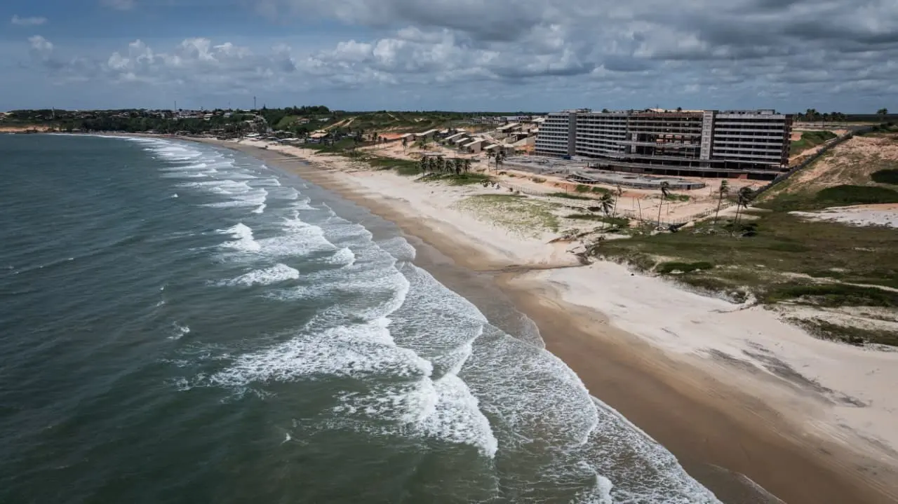 Vista aérea da beira do mar de Lagoinha, com o esqueleto do hotel do Hard Rock a direita.