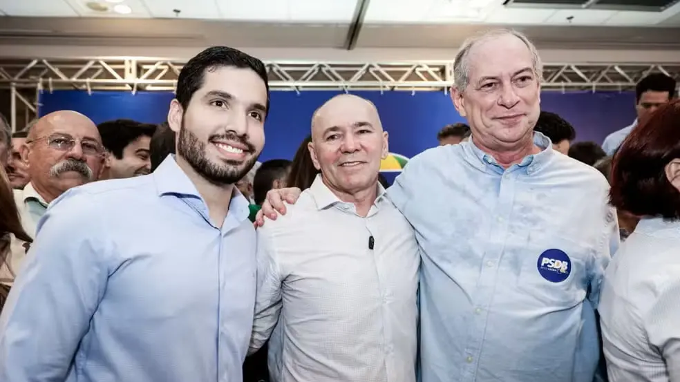 Foto mostra André Fernandes, Pastor Alcides e Ciro Gomes abraçados em evento partidário.
