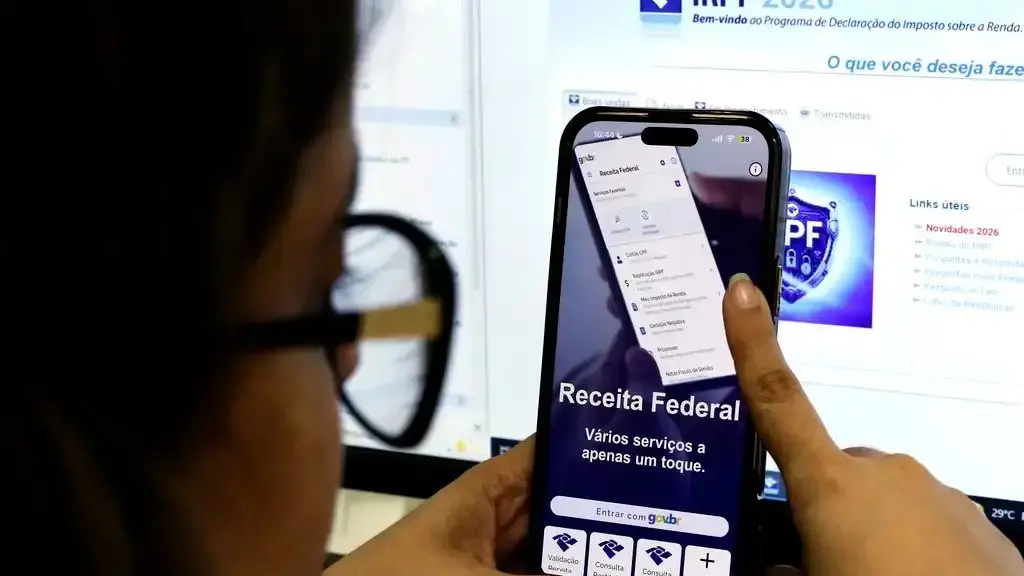 Contribuinte com celular aberto para usar O IR.