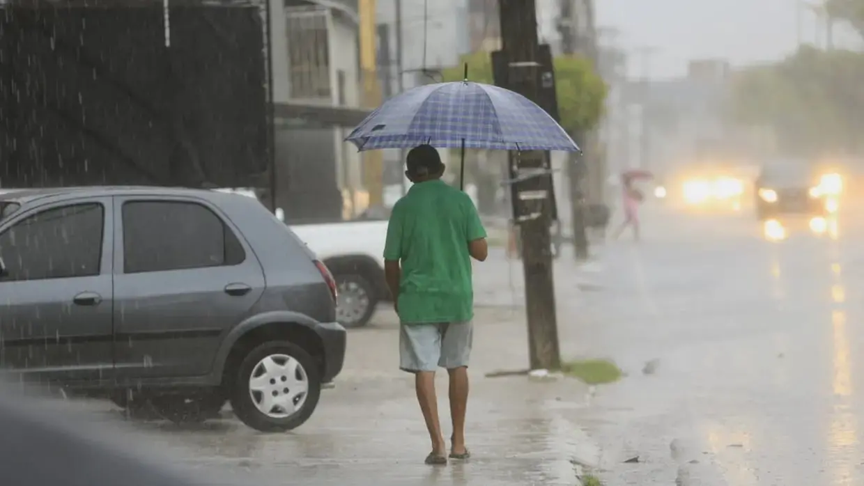 homem segura guarda-chuva foto chuva, carros, rua alagada.
