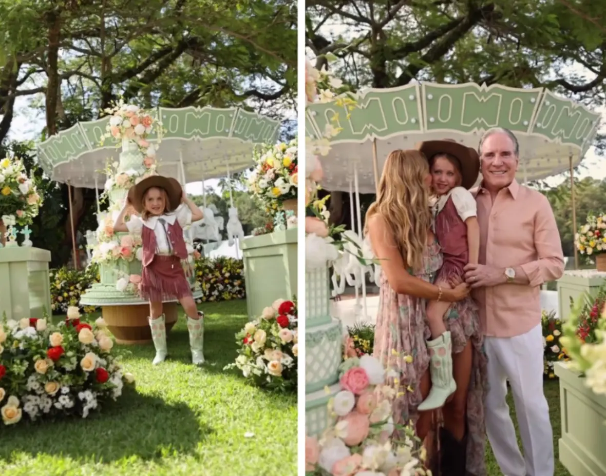 Duas fotos lado a lado mostram uma criança em um cenário decorado ao ar livre, com arranjos de flores e um carrossel ao fundo; em uma imagem, a criança posa sozinha ao lado do bolo, e na outra aparece sendo segurada por duas pessoas adultas próximas à mesa decorada.
